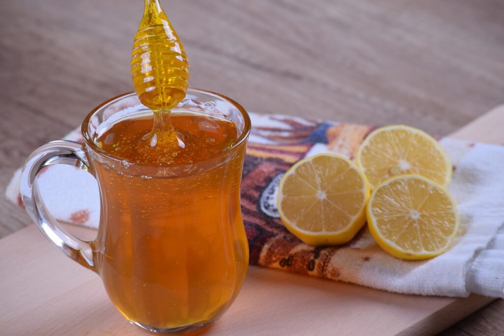 A Honey cup with three slice of Lemon on a towel on the table.