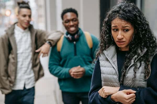 A lady feeling intimidated by two men discussing about her.